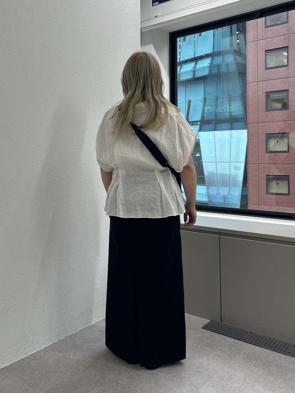 ブラック系のショルダーバッグ、ブラック系のスカート、ブラック系のローファーを着用したレディースの春コーディネートの3枚目の写真