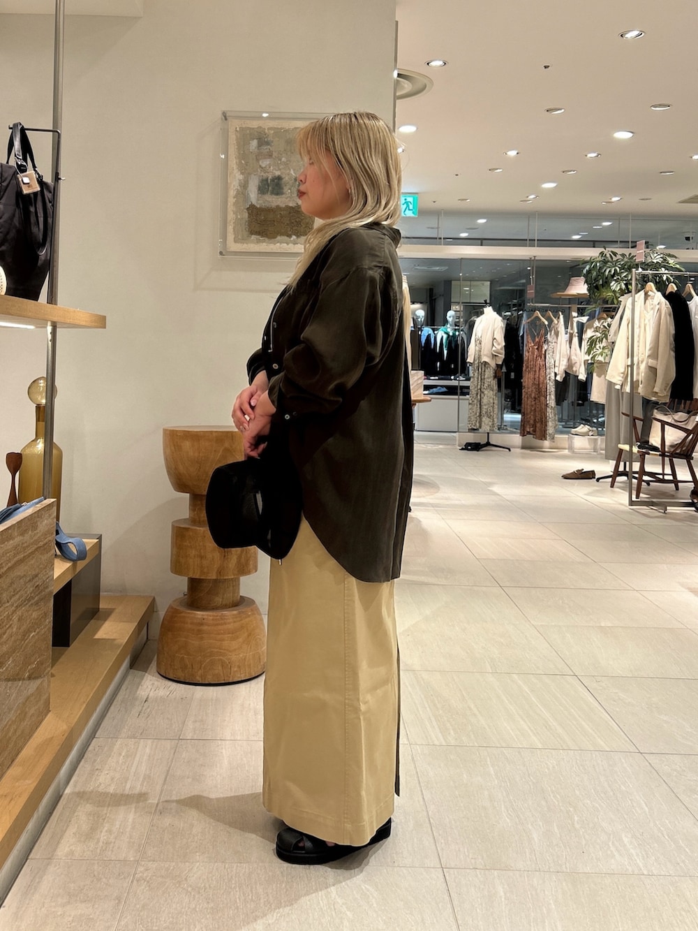 グリーン系のシャツ/ブラウス、ブラック系のサンダル、ベージュ系のスカートを着用したレディースの春コーディネートの3枚目の写真