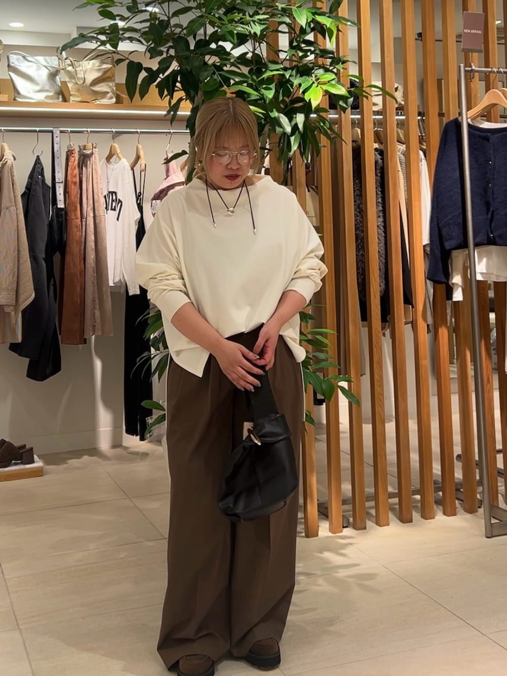 ホワイト系のTシャツ/カットソー、ブラウン系のその他パンツ、ブラック系のトートバッグを着用したレディースの秋コーディネートの4枚目の写真