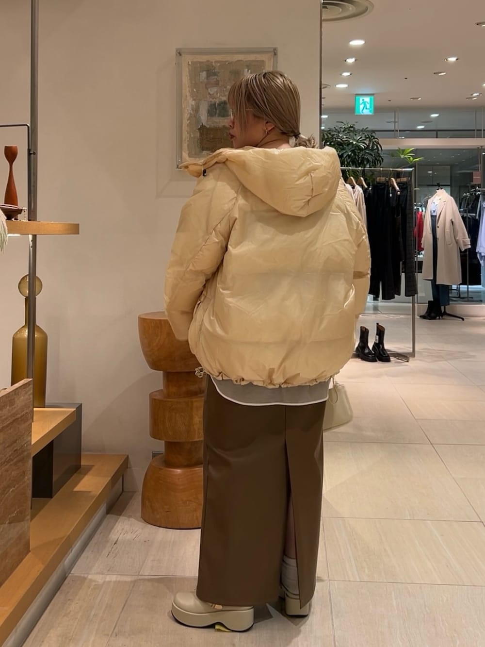 ホワイト系のシャツ/ブラウス、ブラウン系のニット/セーター、ベージュ系のダウンジャケット/コートを着用したレディースの秋コーディネートの2枚目の写真