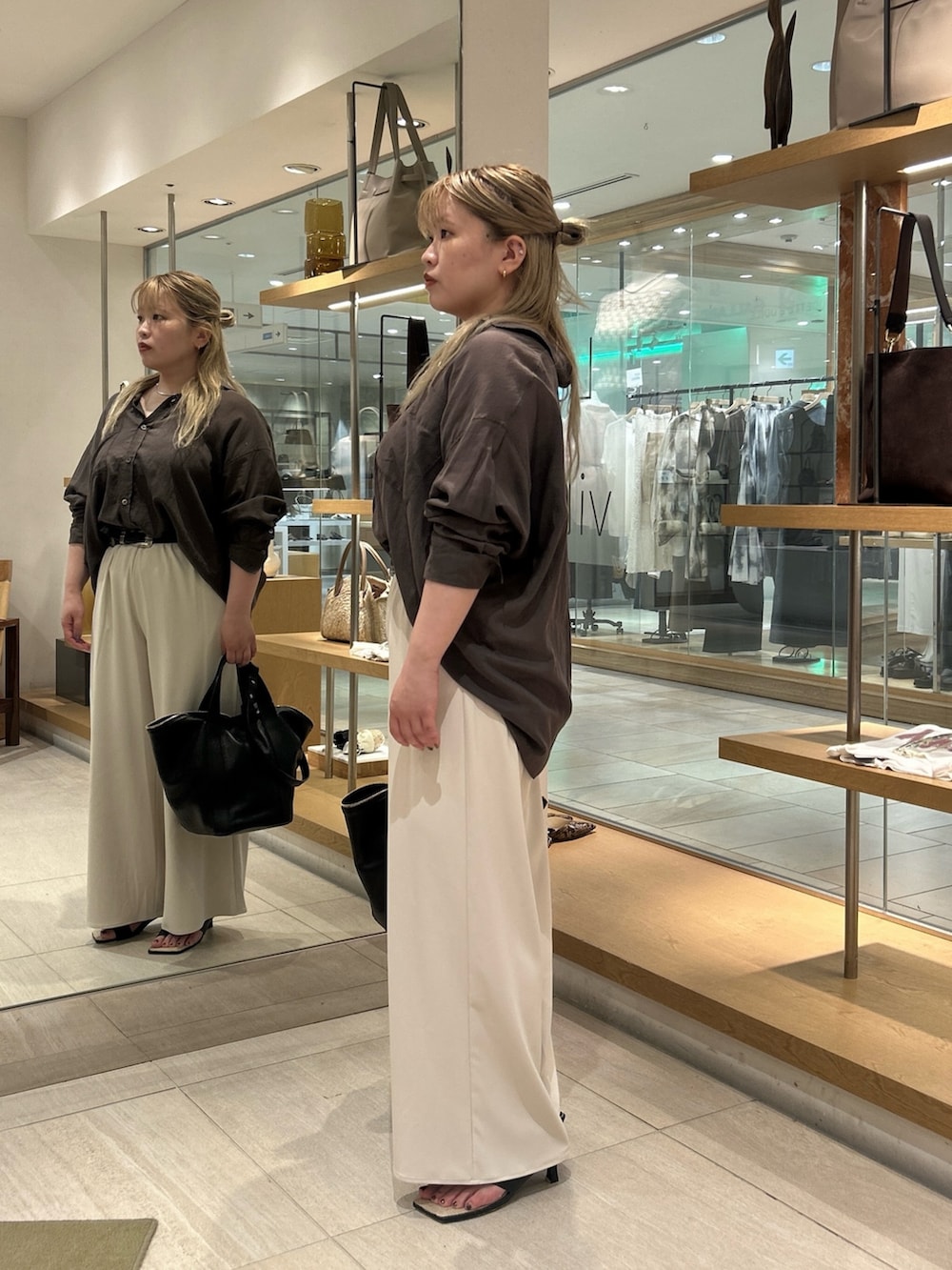 グレー系のシャツ/ブラウス、ベージュ系のその他パンツ、ブラック系のハンドバッグを着用したレディースの夏コーディネートの3枚目の写真