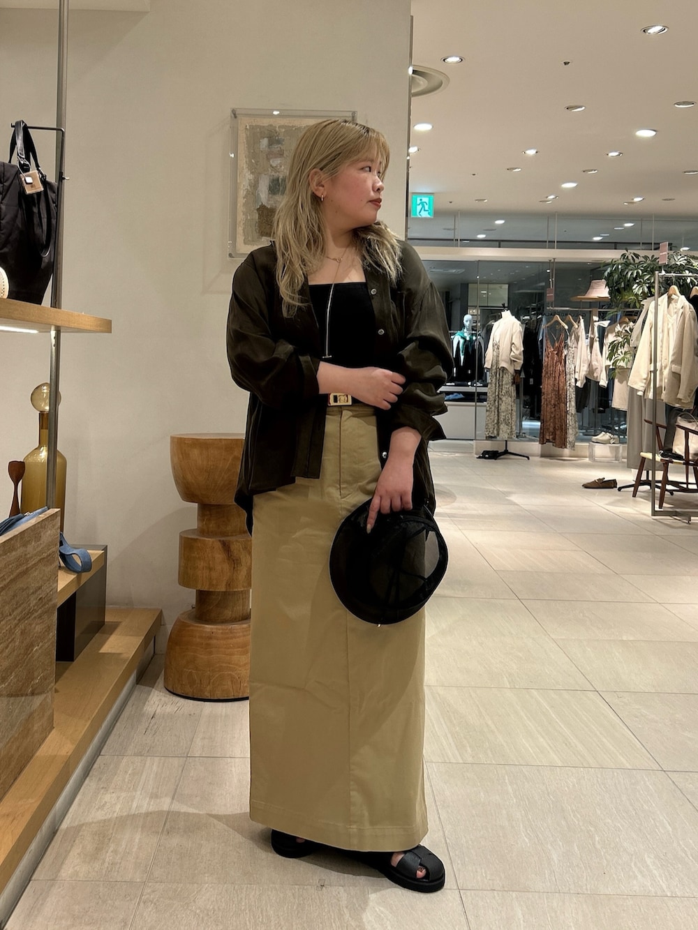 グリーン系のシャツ/ブラウス、ブラック系のサンダル、ベージュ系のスカートを着用したレディースの春コーディネートの4枚目の写真