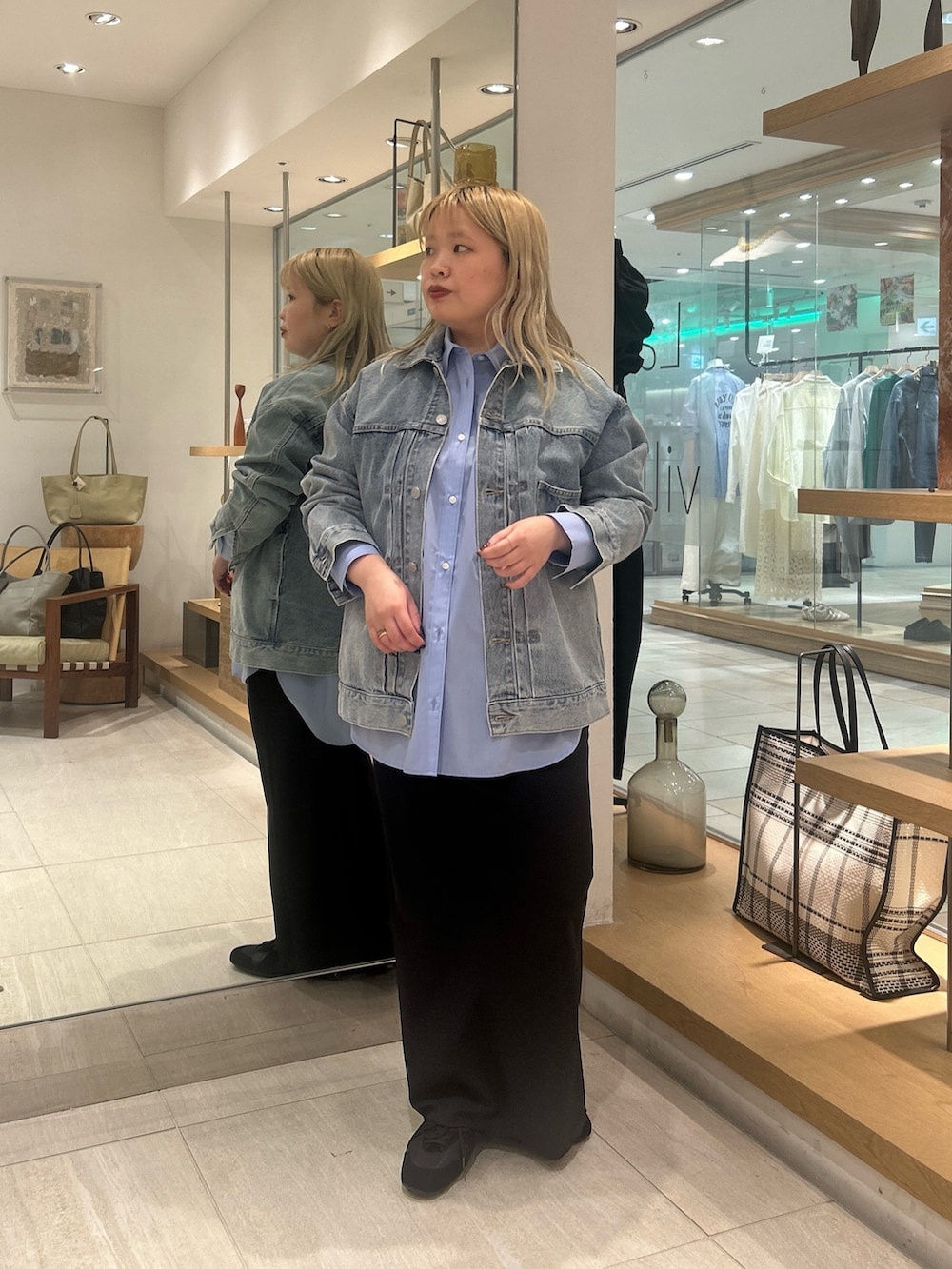 ブルー系のベスト、ブルー系のシャツ/ブラウス、ブラック系のスカートを着用したレディースの冬コーディネートの2枚目の写真