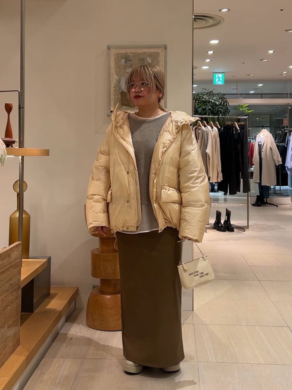 ホワイト系のシャツ/ブラウス、ブラウン系のニット/セーター、ベージュ系のダウンジャケット/コートを着用したレディースの秋コーディネートの6枚目の写真