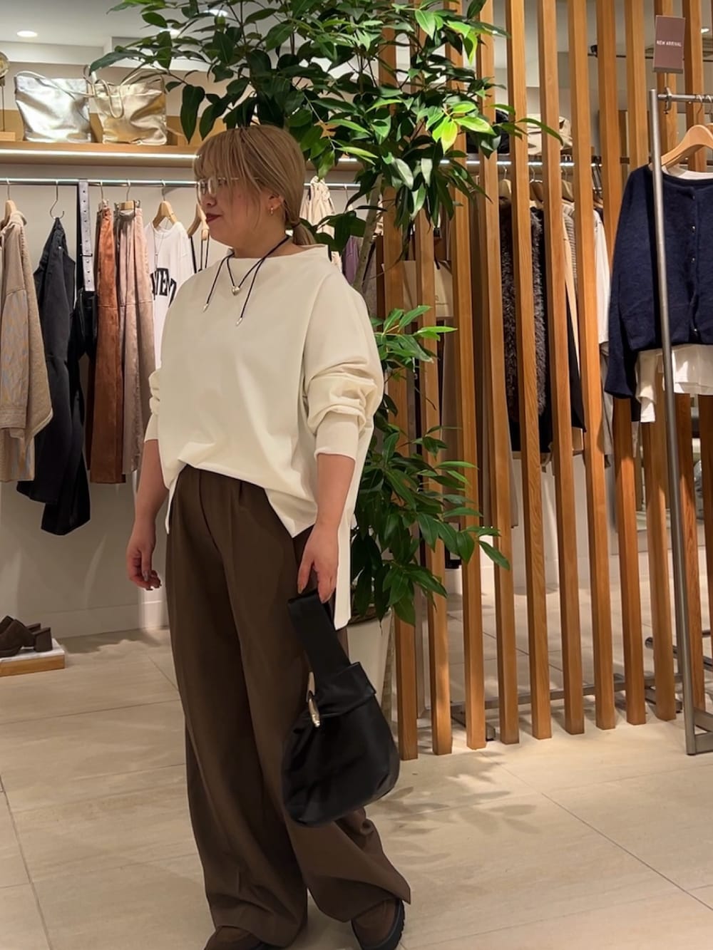 ホワイト系のTシャツ/カットソー、ブラウン系のその他パンツ、ブラック系のトートバッグを着用したレディースの秋コーディネートの3枚目の写真
