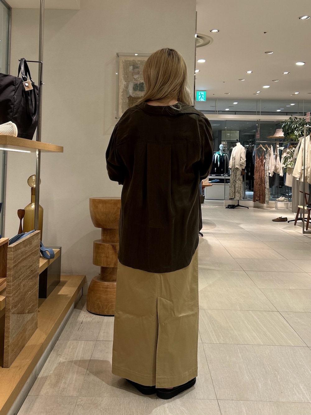 グリーン系のシャツ/ブラウス、ブラック系のサンダル、ベージュ系のスカートを着用したレディースの春コーディネートの2枚目の写真