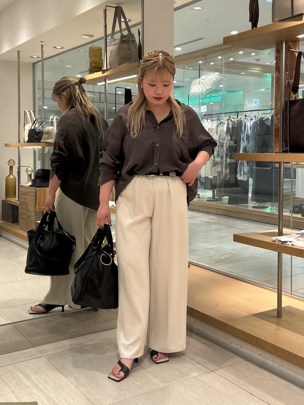 グレー系のシャツ/ブラウス、ベージュ系のその他パンツ、ブラック系のハンドバッグを着用したレディースの夏コーディネートの4枚目の写真
