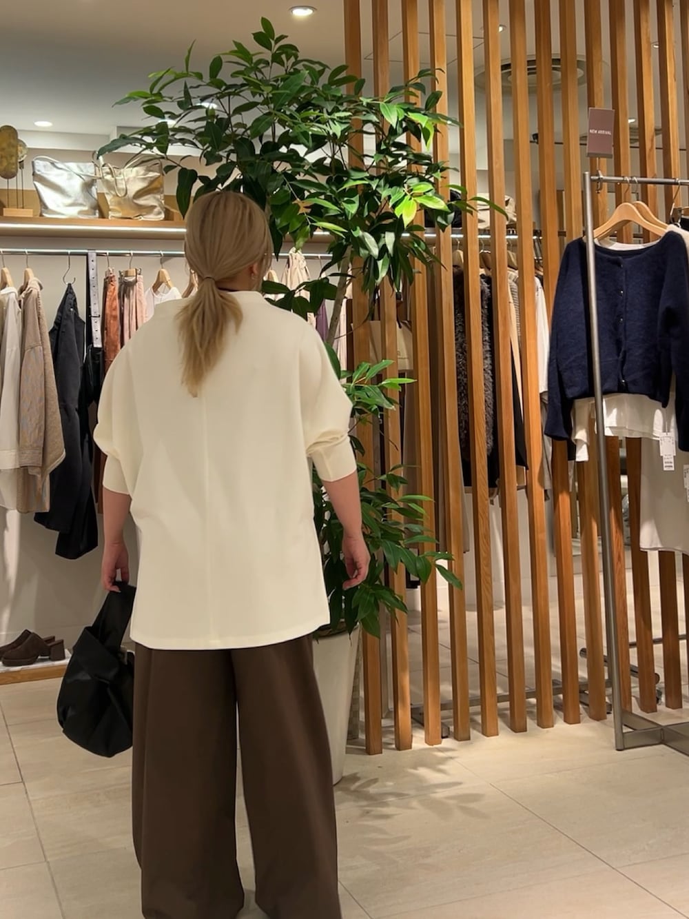 ホワイト系のTシャツ/カットソー、ブラウン系のその他パンツ、ブラック系のトートバッグを着用したレディースの秋コーディネートの2枚目の写真