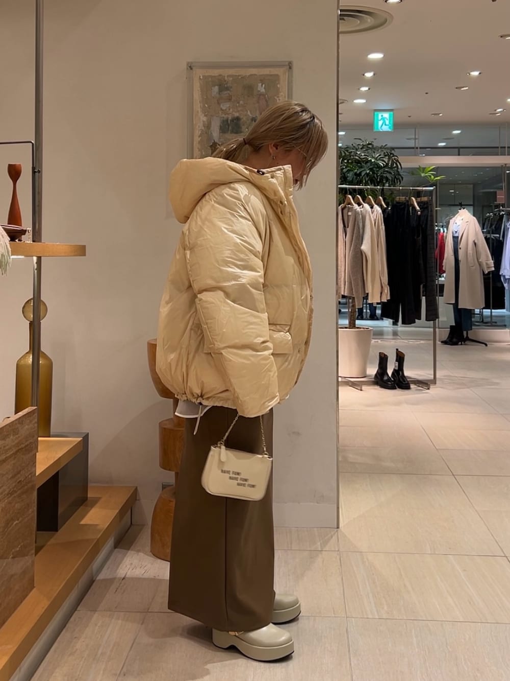 ホワイト系のシャツ/ブラウス、ブラウン系のニット/セーター、ベージュ系のダウンジャケット/コートを着用したレディースの秋コーディネートの3枚目の写真