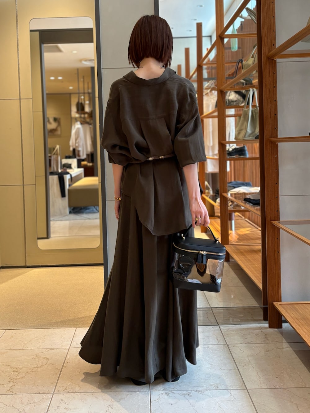 グリーン系のシャツ/ブラウス、グリーン系のスカート、ブラック系のショルダーバッグを着用したレディースの春コーディネートの3枚目の写真