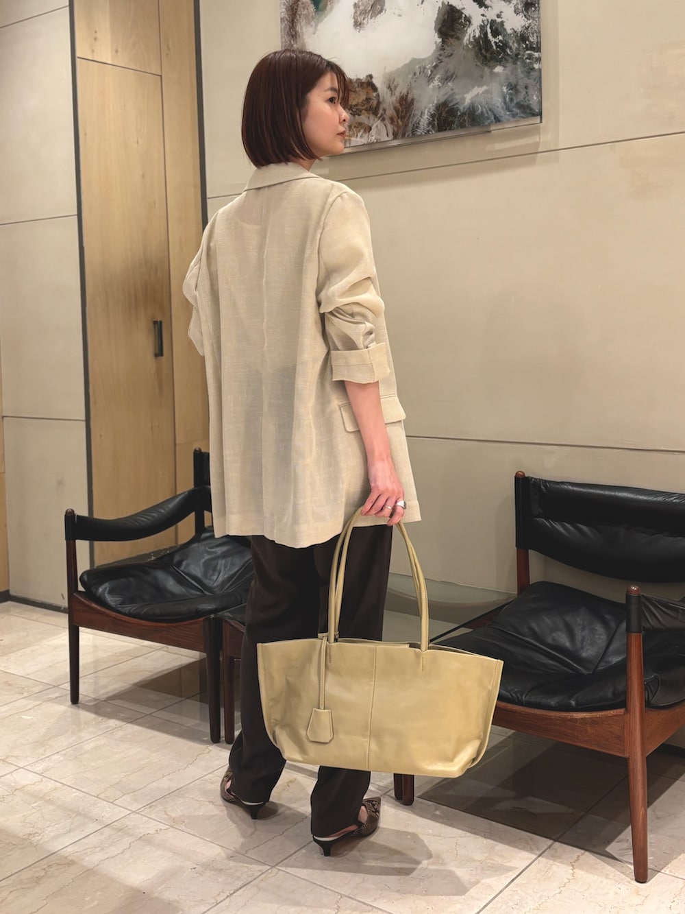 ブラウン系のその他パンツ、ブラウン系のパンプス、ベージュ系のトートバッグを着用したレディースの春コーディネートの2枚目の写真