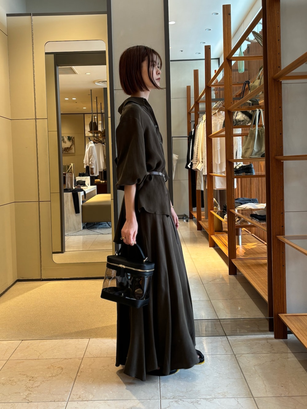 グリーン系のシャツ/ブラウス、グリーン系のスカート、ブラック系のショルダーバッグを着用したレディースの春コーディネートの2枚目の写真