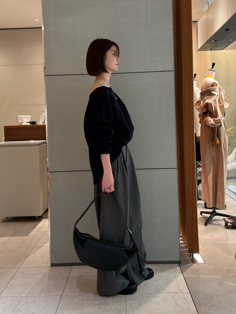 グレー系のその他パンツ、ブラック系のTシャツ/カットソー、ブラック系のショルダーバッグを着用したレディースの冬コーディネートの2枚目の写真