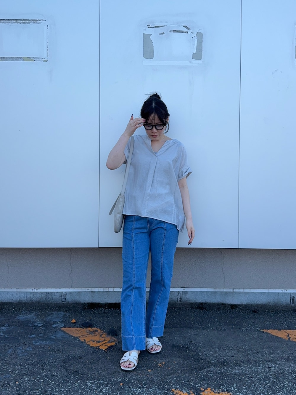 グレー系のシャツ/ブラウス、ブルー系のデニムパンツを着用したレディースの夏コーディネートの3枚目の写真