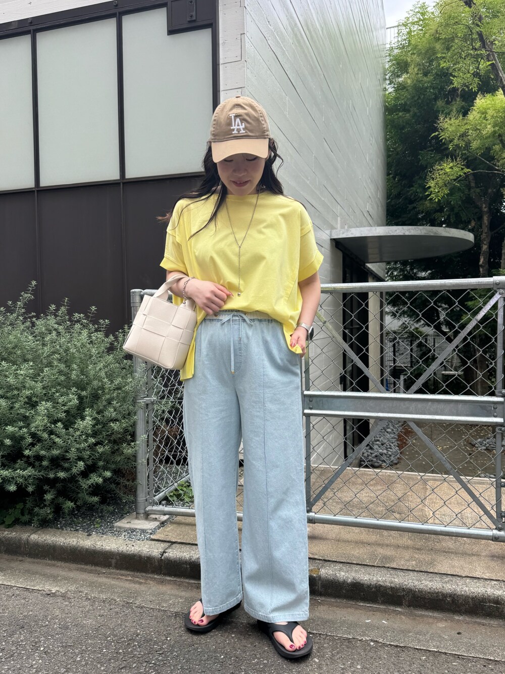 ブルー系のデニムパンツ、イエロー系のTシャツ/カットソーを着用したレディースの夏コーディネートの2枚目の写真