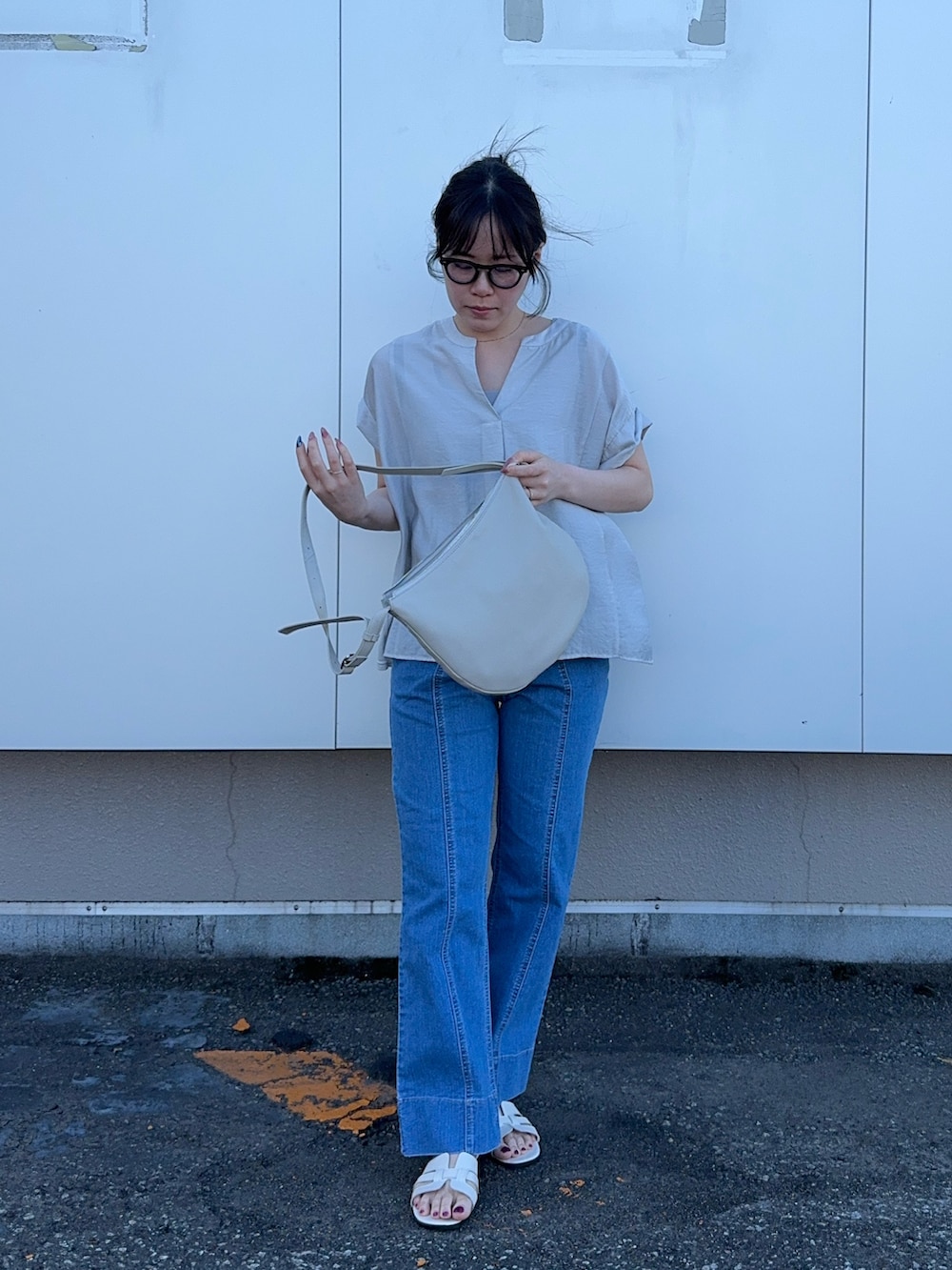 グレー系のシャツ/ブラウス、ブルー系のデニムパンツを着用したレディースの夏コーディネートの2枚目の写真