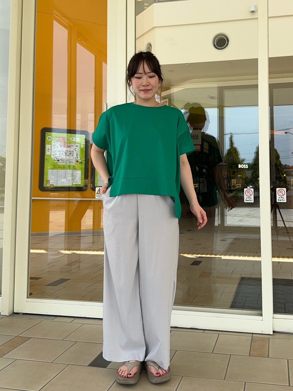 グレー系のその他パンツ、グリーン系のTシャツ/カットソーを着用したレディースの夏コーディネートの2枚目の写真