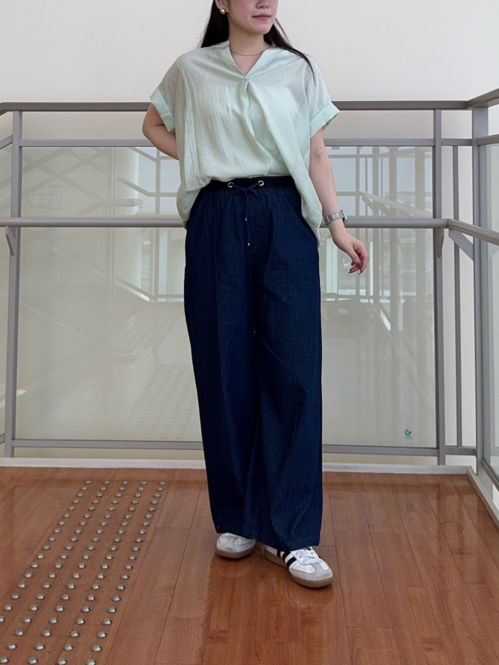 グリーン系のシャツ/ブラウス、ブルー系のデニムパンツを着用したレディースの夏コーディネートの3枚目の写真