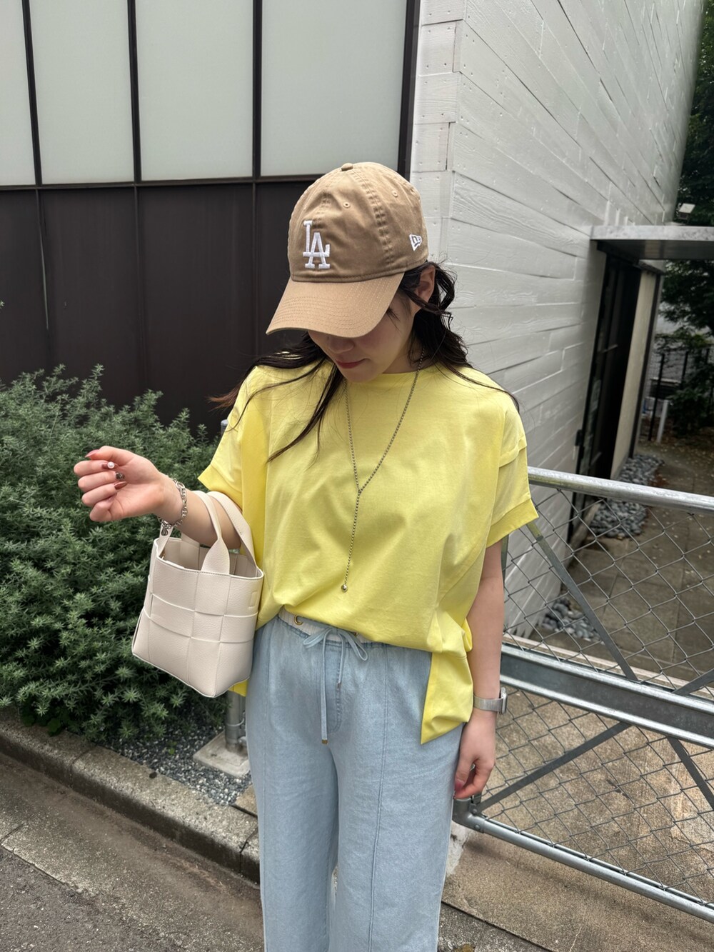 ブルー系のデニムパンツ、イエロー系のTシャツ/カットソーを着用したレディースの夏コーディネートの3枚目の写真