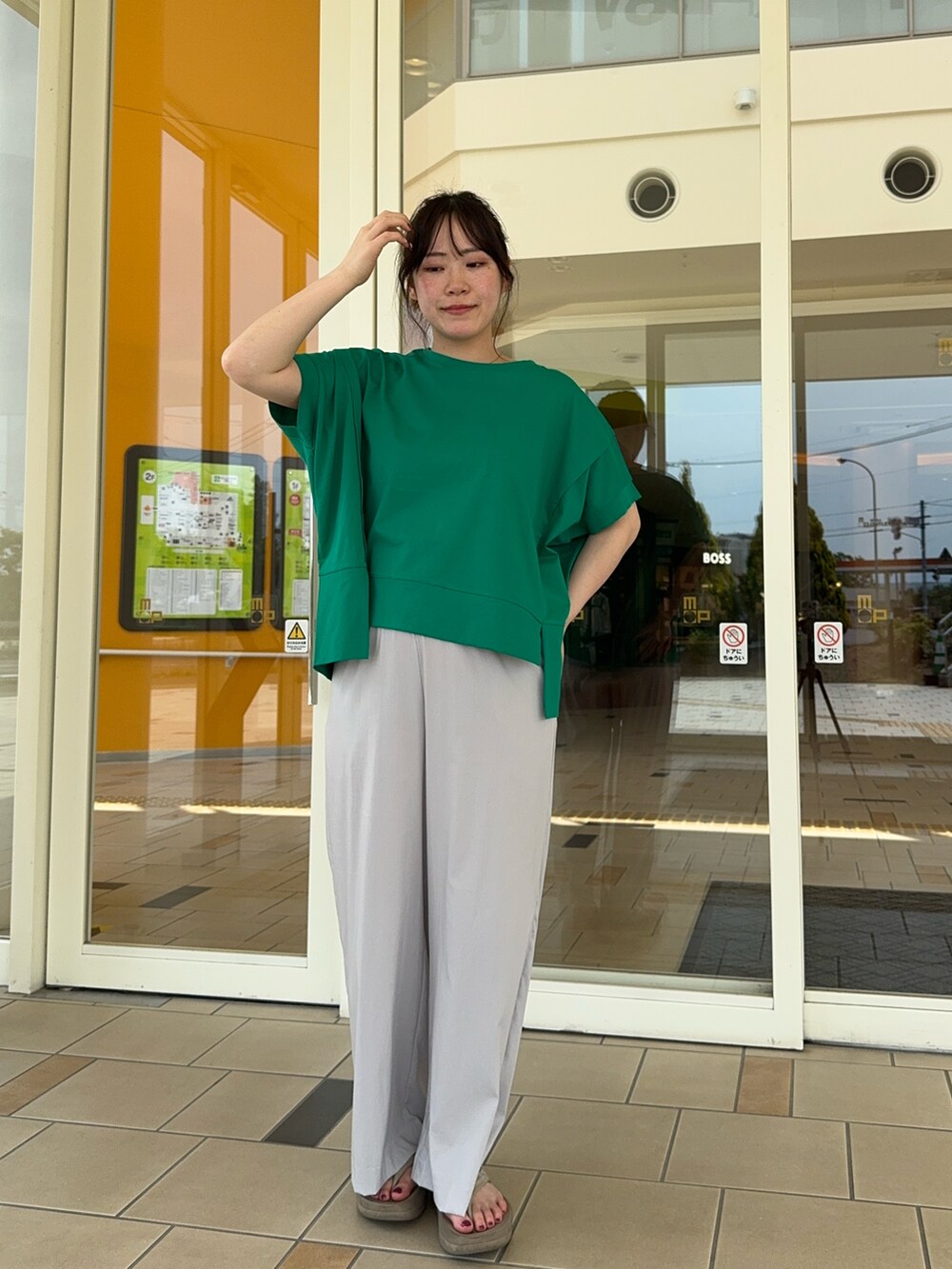 グレー系のその他パンツ、グリーン系のTシャツ/カットソーを着用したレディースの夏コーディネートの3枚目の写真