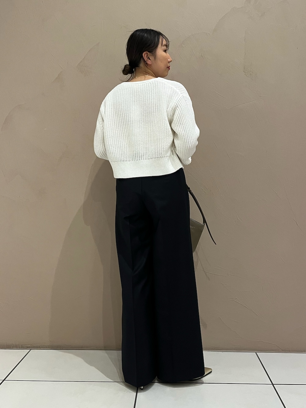 ブルー系のスラックス、ブラウン系のショルダーバッグ、ゴールド系のパンプスを着用したレディースの春コーディネートの3枚目の写真