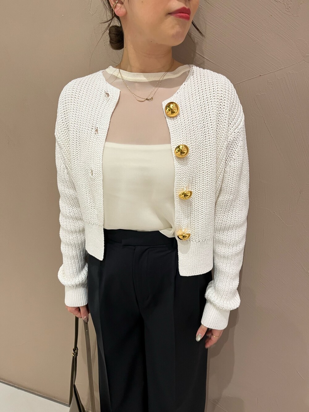 ブルー系のスラックス、ブラウン系のショルダーバッグ、ゴールド系のパンプスを着用したレディースの春コーディネートの2枚目の写真