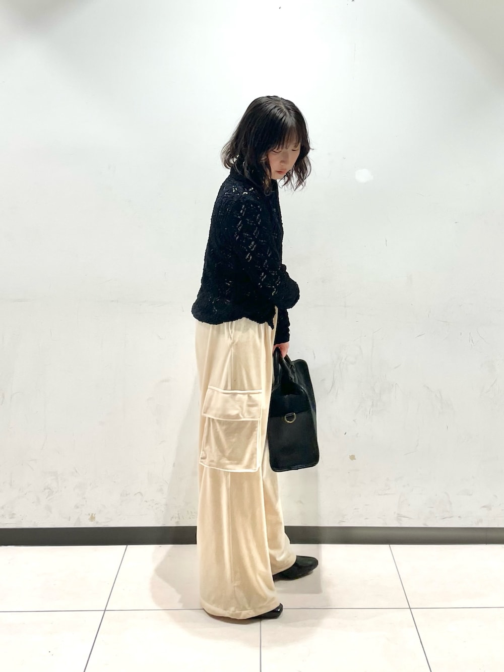 ブラック系のニット/セーター、ベージュ系のその他パンツ、グレー系のボストンバッグを着用したレディースの冬コーディネートの2枚目の写真