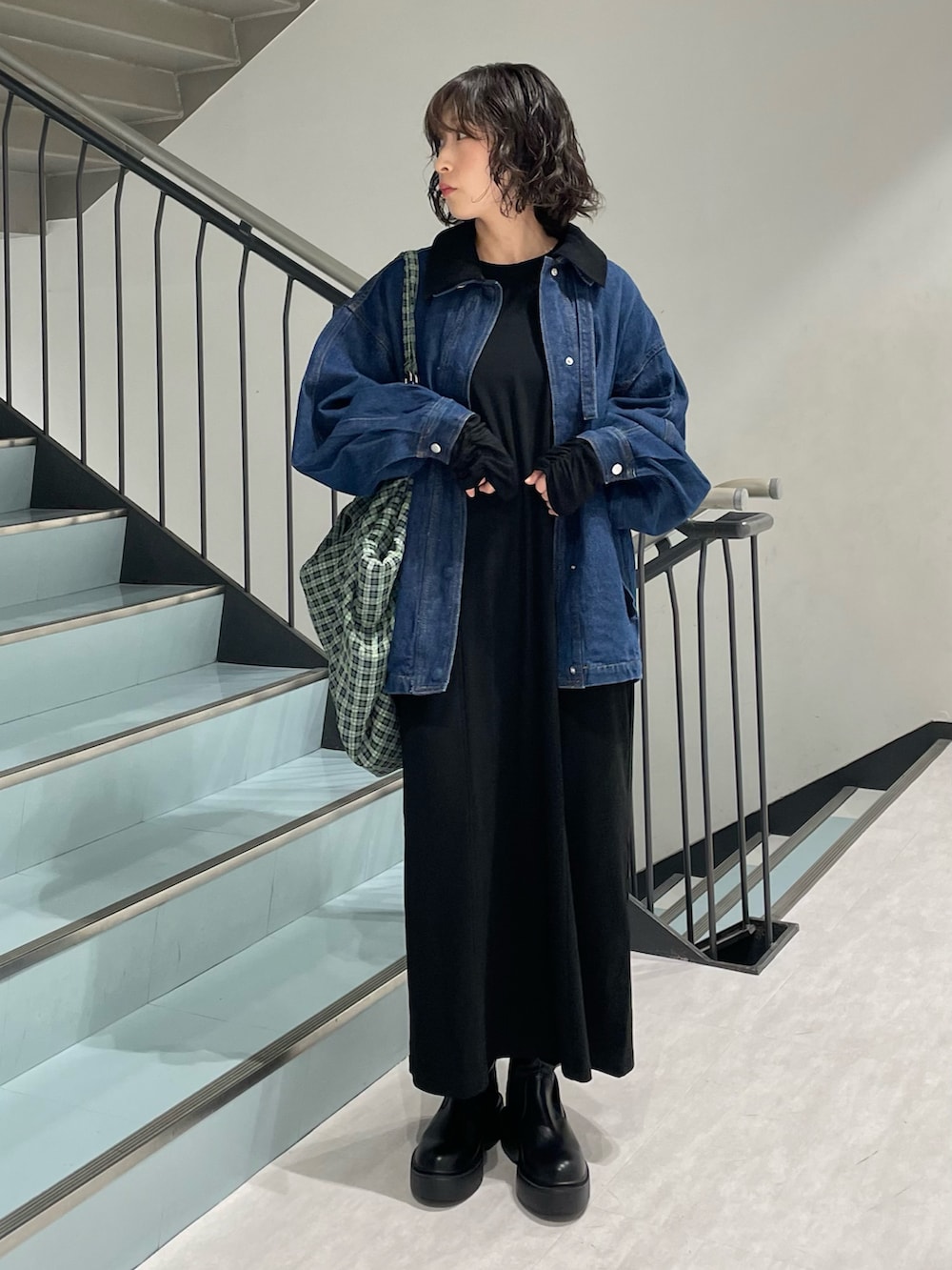 ブルー系のブルゾン、ブラック系のワンピース、ブラック系のブーツを着用したレディースの秋コーディネートの2枚目の写真