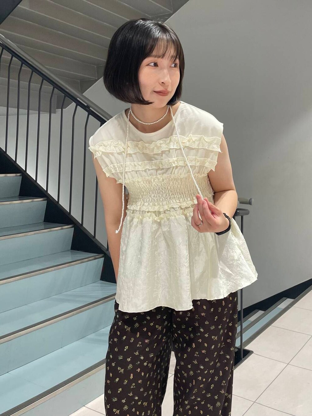 ブラウン系のスニーカー、ブラウン系のその他パンツ、ホワイト系のTシャツ/カットソーを着用したレディースの夏コーディネートの2枚目の写真