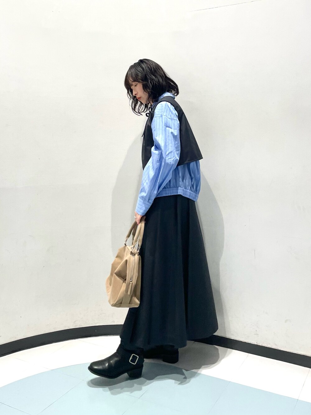 グレー系のワンピース、ブルー系のシャツ/ブラウス、ベージュ系のボストンバッグを着用したレディースの冬コーディネートの4枚目の写真