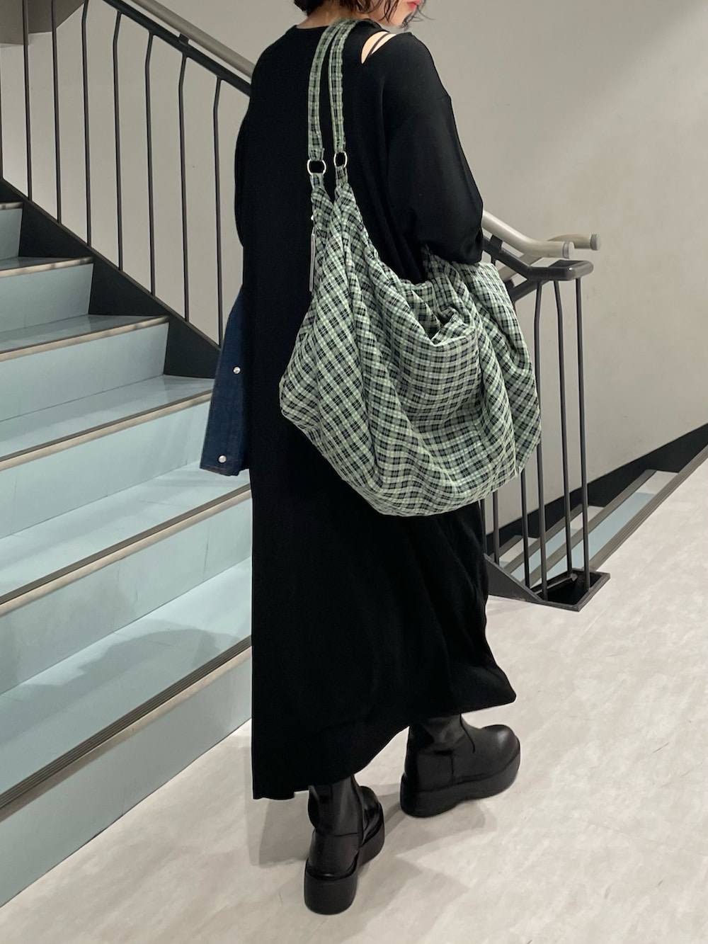 ブルー系のブルゾン、ブラック系のワンピース、ブラック系のブーツを着用したレディースの秋コーディネートの5枚目の写真