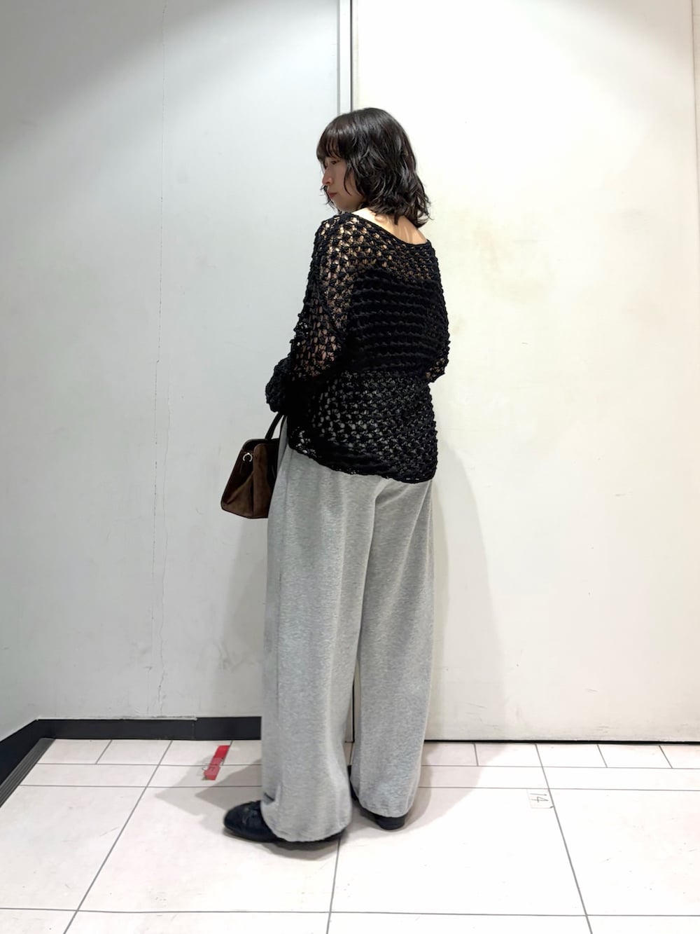 ブラック系のニット/セーター、グレー系のその他パンツ、ブラック系のその他シューズを着用したレディースの春コーディネートの2枚目の写真