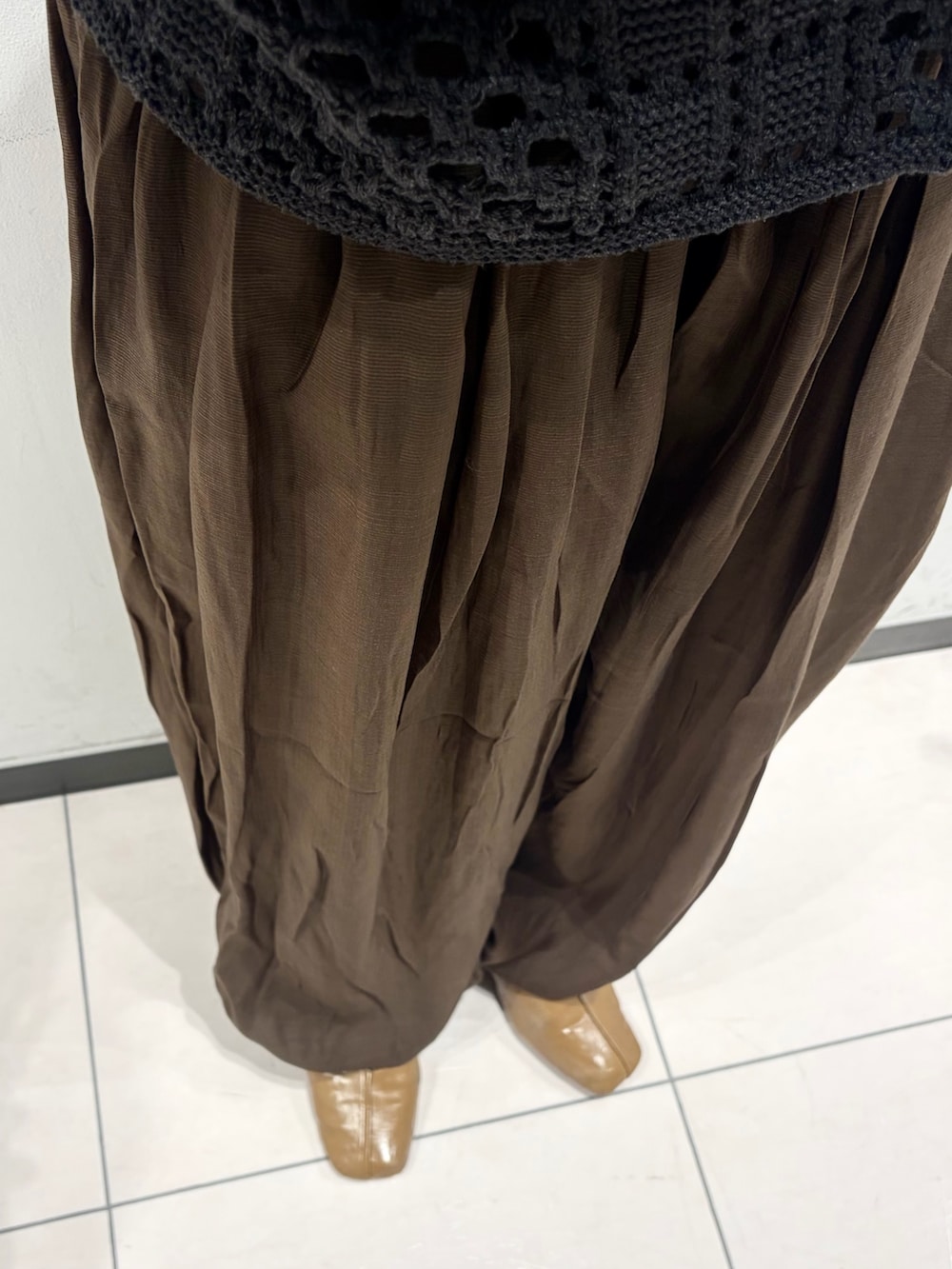 ブラウン系のその他パンツ、グレー系のニット/セーター、ブラウン系のキャミソールを着用したレディースの春コーディネートの6枚目の写真