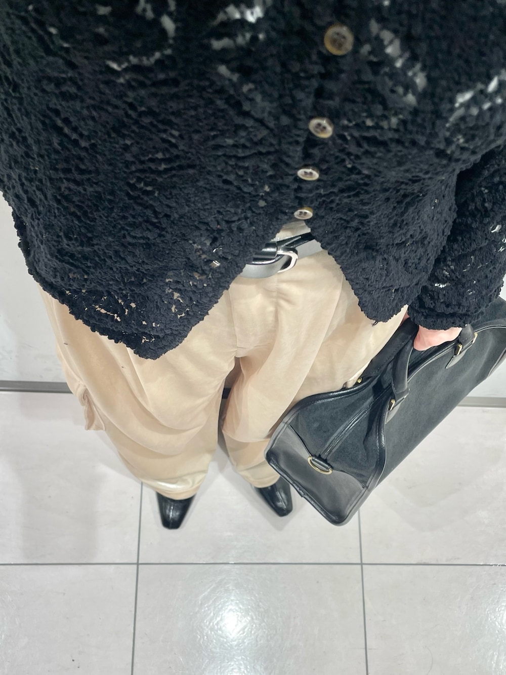 ブラック系のニット/セーター、ベージュ系のその他パンツ、グレー系のボストンバッグを着用したレディースの冬コーディネートの5枚目の写真