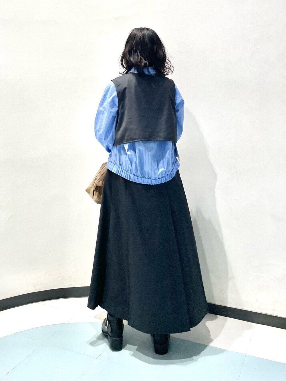 グレー系のワンピース、ブルー系のシャツ/ブラウス、ベージュ系のボストンバッグを着用したレディースの冬コーディネートの3枚目の写真