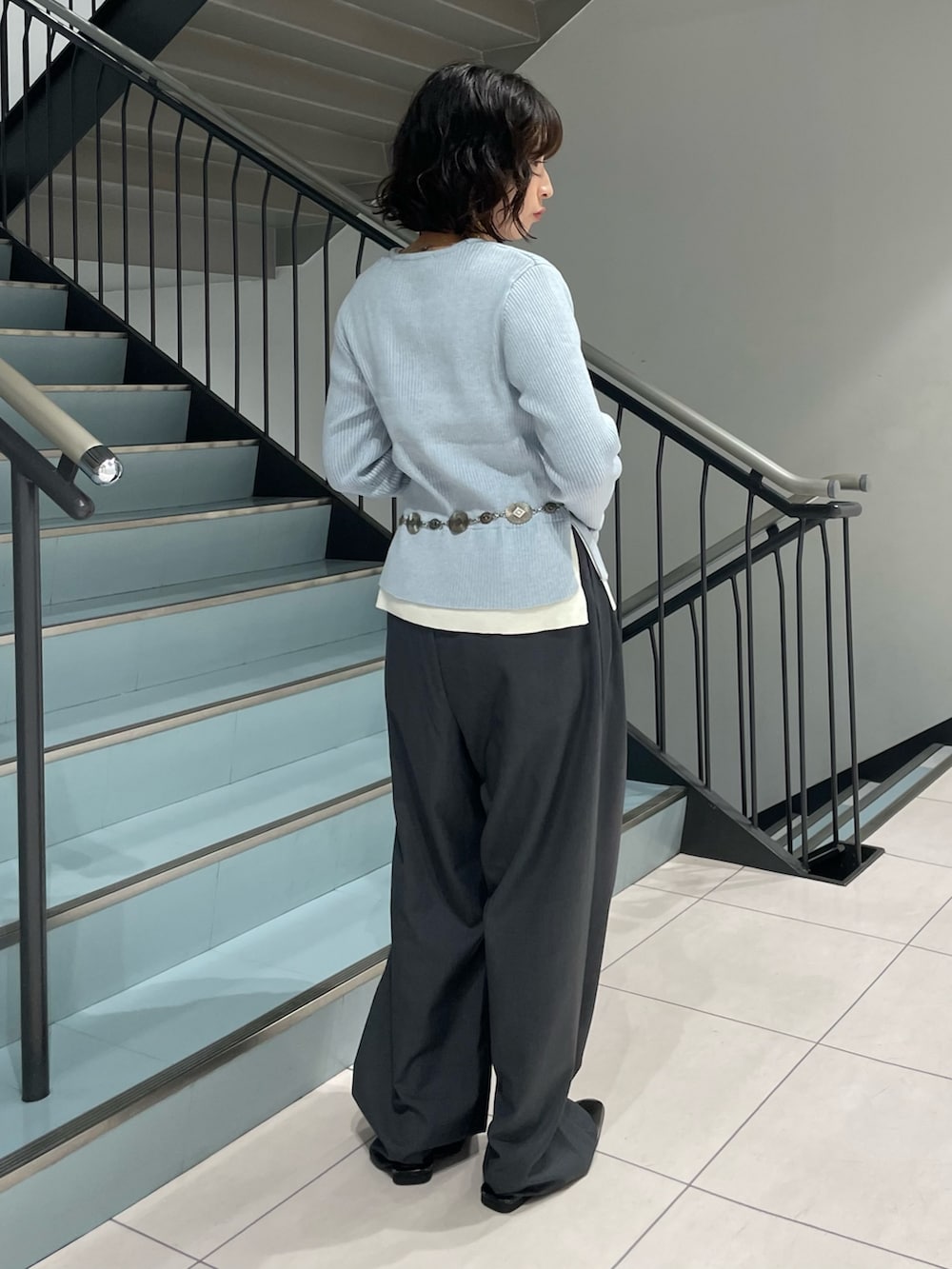 ブルー系のニット/セーター、グレー系のその他パンツ、シルバー系のネックレスを着用したレディースの秋コーディネートの3枚目の写真