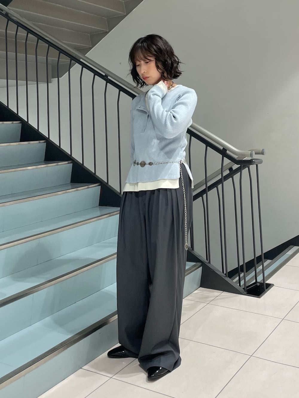 ブルー系のニット/セーター、グレー系のその他パンツ、シルバー系のネックレスを着用したレディースの秋コーディネートの2枚目の写真