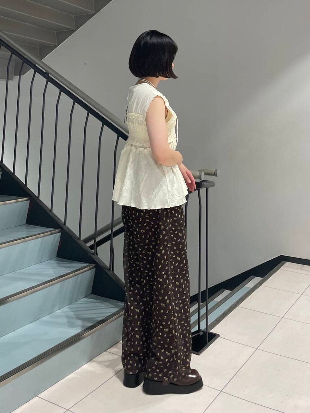 ブラウン系のスニーカー、ブラウン系のその他パンツ、ホワイト系のTシャツ/カットソーを着用したレディースの夏コーディネートの3枚目の写真