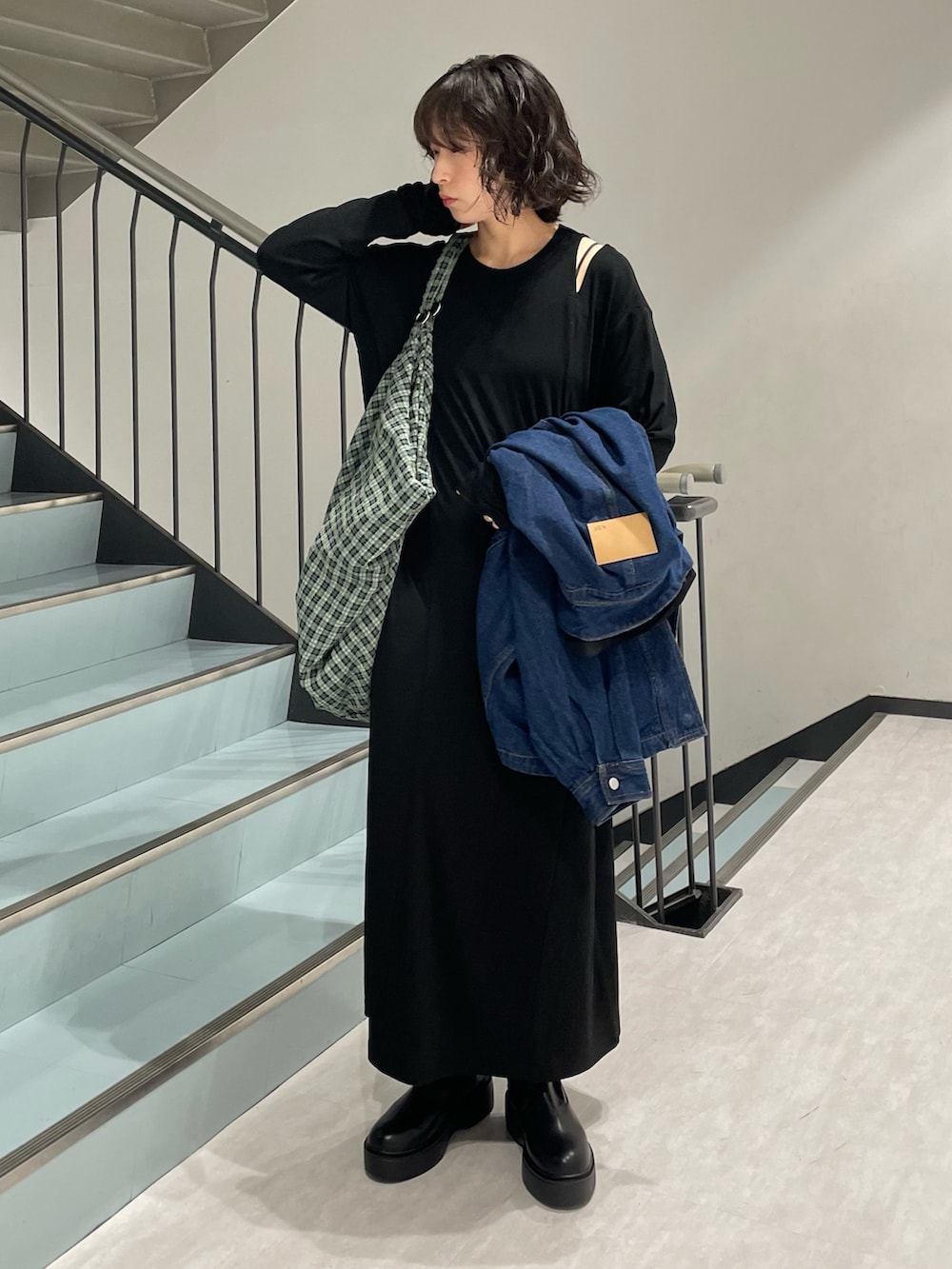 ブルー系のブルゾン、ブラック系のワンピース、ブラック系のブーツを着用したレディースの秋コーディネートの3枚目の写真