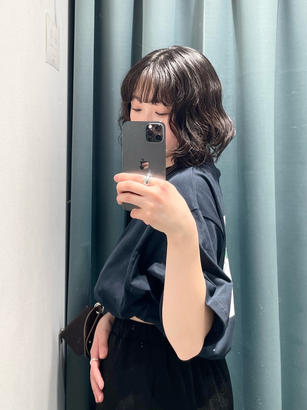 ブラック系のスカート、ブルー系のTシャツ/カットソー、ホワイト系のサンダルを着用したレディースの冬コーディネートの5枚目の写真