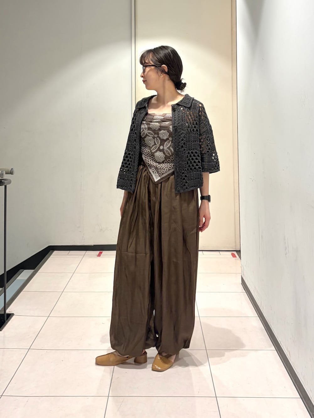 ブラウン系のその他パンツ、グレー系のニット/セーター、ブラウン系のキャミソールを着用したレディースの春コーディネートの2枚目の写真