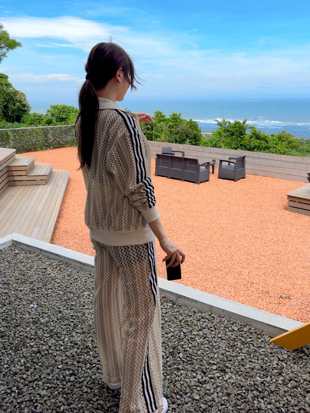 ベージュ系のセットアップ、ブラック系のサングラスを着用したレディースの夏コーディネートの2枚目の写真