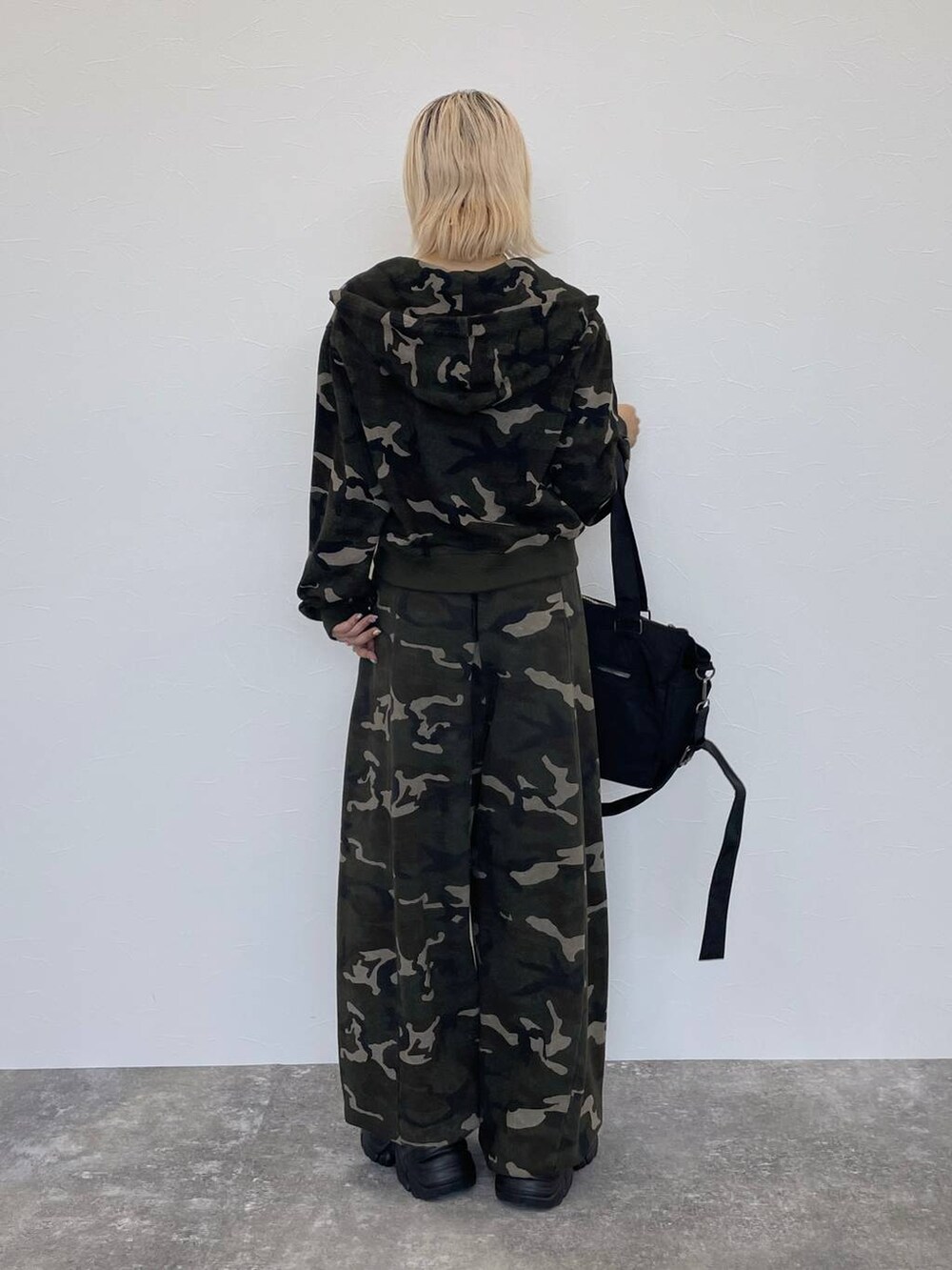 ブラック系のスニーカー、ブラック系のキャミソール、その他のスウェットパンツを着用したレディースの秋コーディネートの2枚目の写真