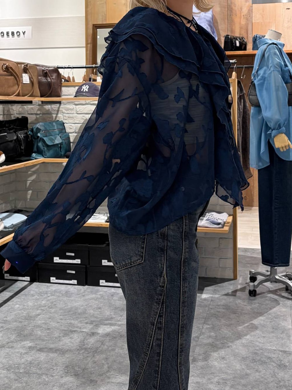 ブラウン系のブーツ、ブルー系のデニムパンツ、イエロー系のトートバッグを着用したレディースの春コーディネートの3枚目の写真