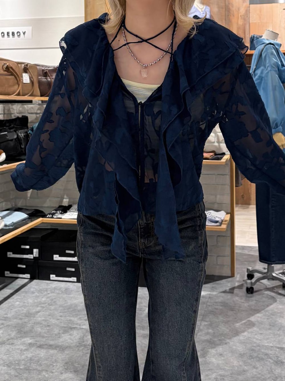 ブラウン系のブーツ、ブルー系のデニムパンツ、イエロー系のトートバッグを着用したレディースの春コーディネートの2枚目の写真