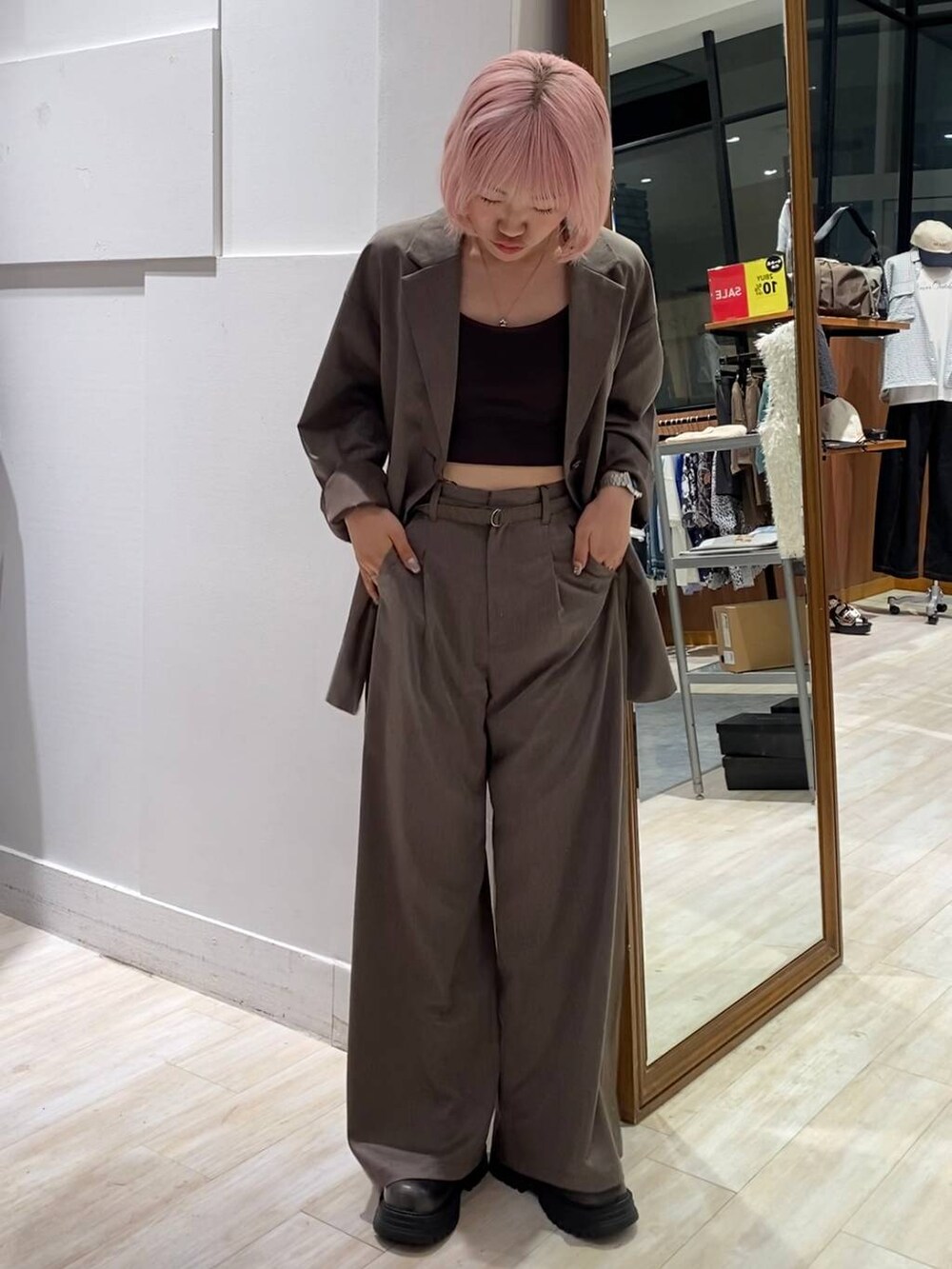 ブラック系のブーツ、ブラウン系のキャミソール、ブラウン系のスラックスを着用したレディースの夏コーディネートの2枚目の写真