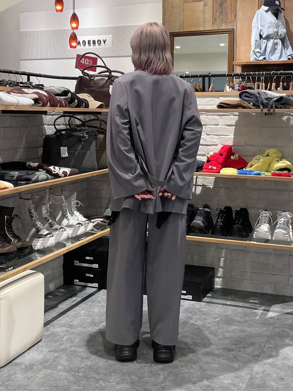 ブラック系のスニーカー、シルバー系のTシャツ/カットソー、グレー系のデニムパンツを着用したレディースの冬コーディネートの4枚目の写真