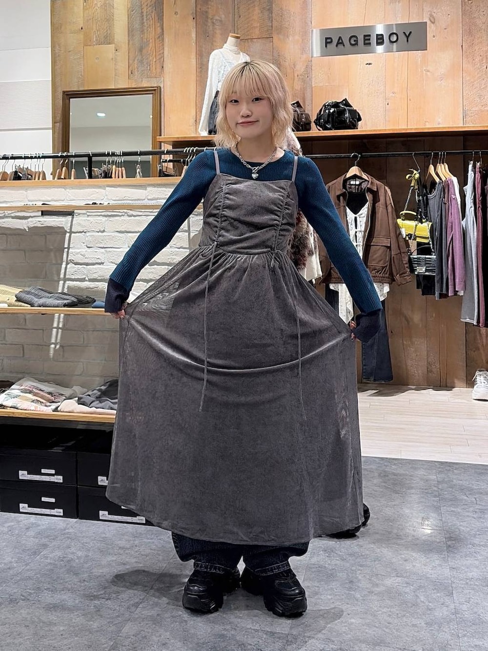 ブラック系のスニーカー、グリーン系のニット/セーター、ブルー系のデニムパンツを着用したレディースの秋コーディネートの4枚目の写真