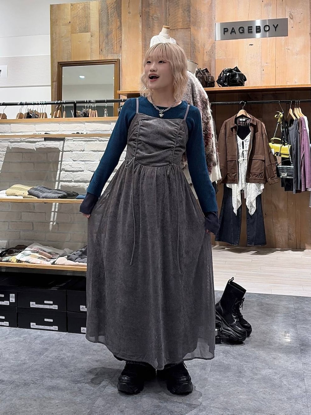 ブラック系のスニーカー、グリーン系のニット/セーター、ブルー系のデニムパンツを着用したレディースの秋コーディネートの3枚目の写真