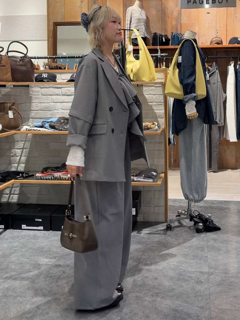 その他のブーツ、ブラウン系のハンドバッグ、グレー系のテーラードジャケットを着用したレディースの春コーディネートの3枚目の写真